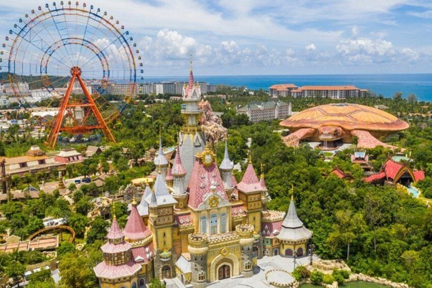 A large amusement park with a Ferris wheel, a castle-like building, and a dome-shaped structure. 5