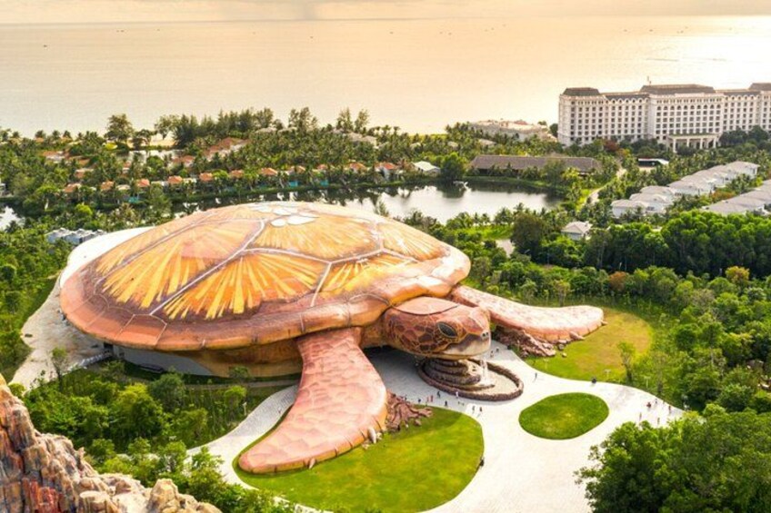 A large mushroom-shaped building surrounded by greenery and water. 4