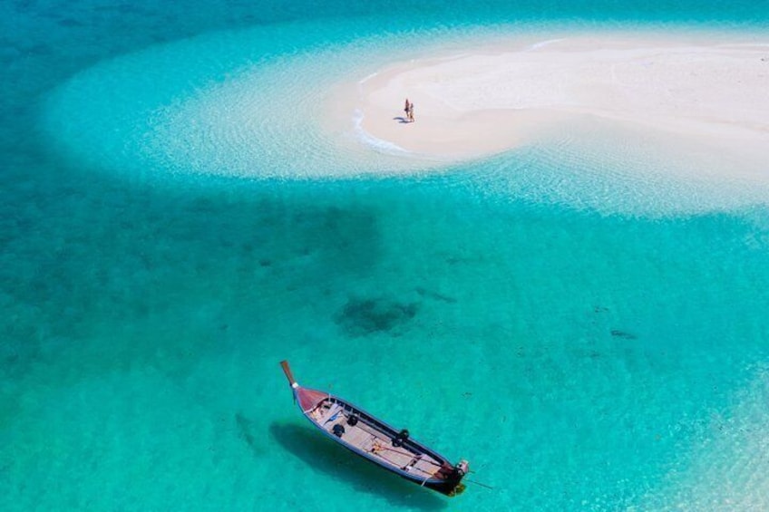 A boat stranded on a turquoise reef near a white sandy beach. 3