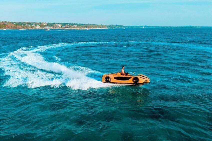 A yellow sports car speeding across a body of water with a wake behind it. 5