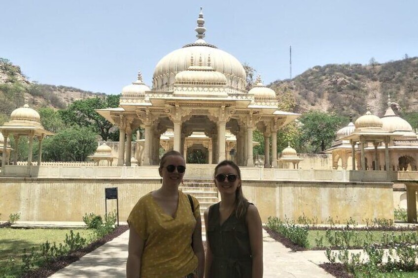 Two people standing in front of a large, ornate building with domes and columns. 4