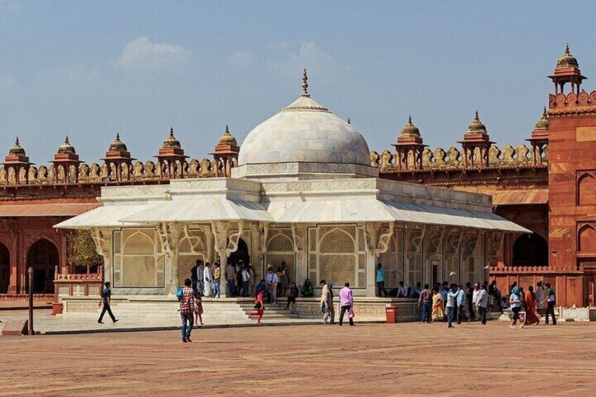A large, domed building with intricate architecture, surrounded by a crowd of people. 1