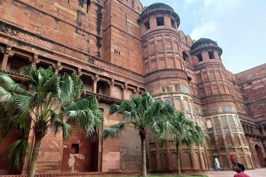 A large, historic building with intricate architecture and palm trees in the foreground. 2
