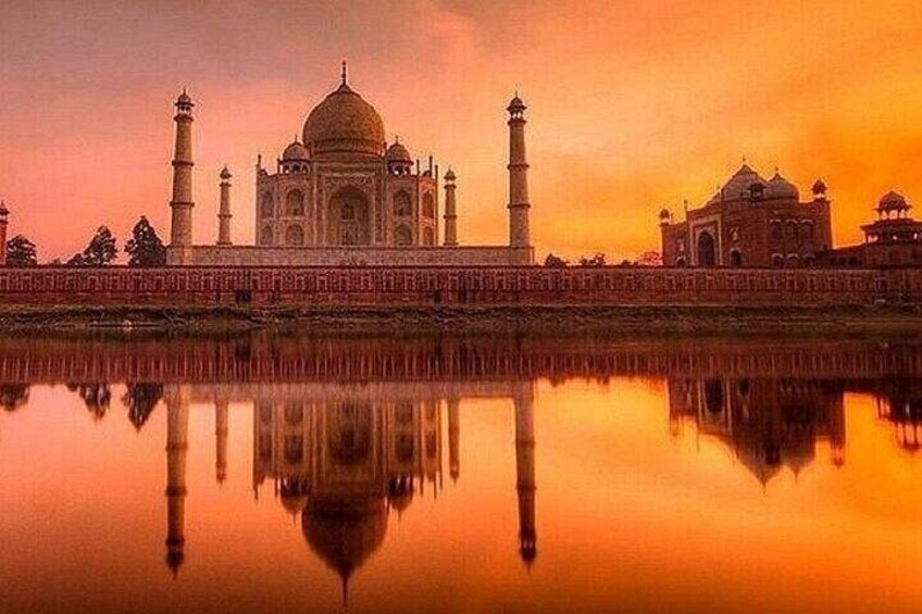 The Taj Mahal with its reflection in the water, surrounded by a red wall. 5