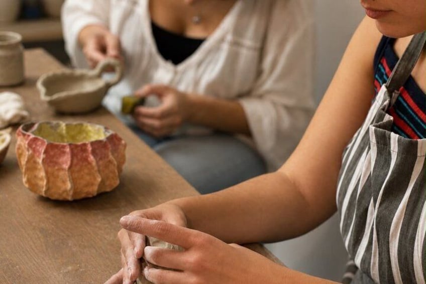 A person shaping clay on a pottery wheel. 1