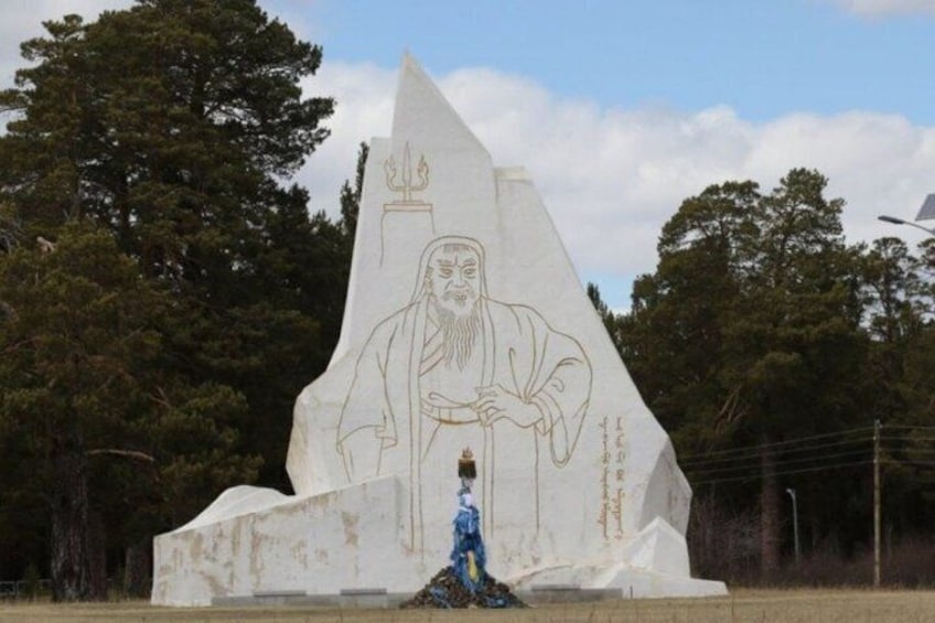 A large white monument with a figure of a man in traditional attire, surrounded by trees. 4