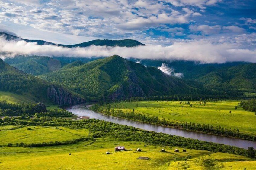 A river winding through a valley with green fields and mountains in the background. 5