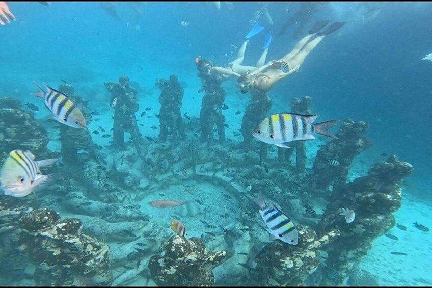 A diver surrounded by marine life and underwater structures. 3