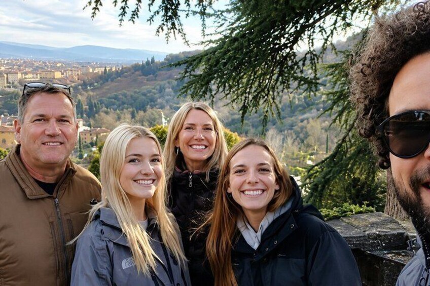 A group of people standing outdoors with a mountainous landscape in the background. 3