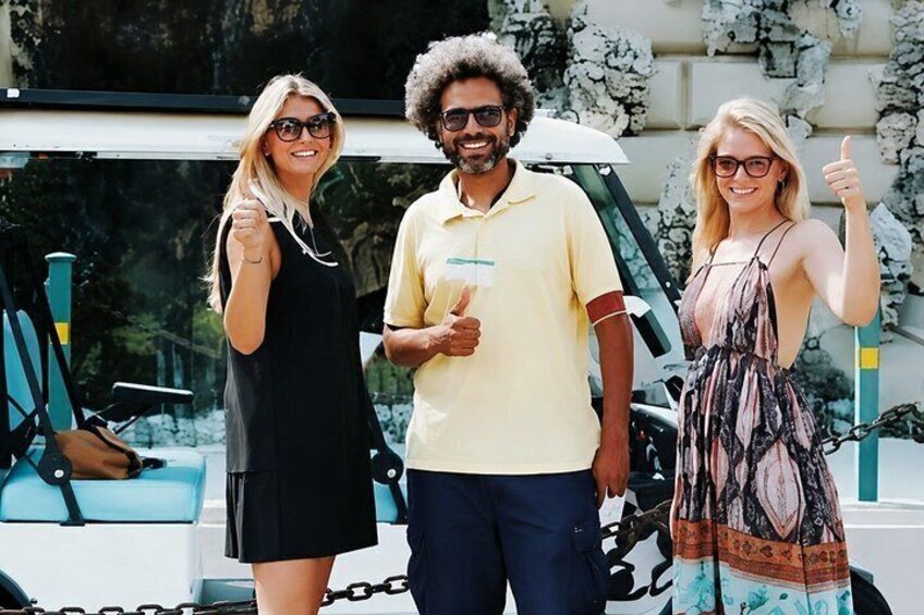 Three people standing in front of a white vehicle with chains. 1