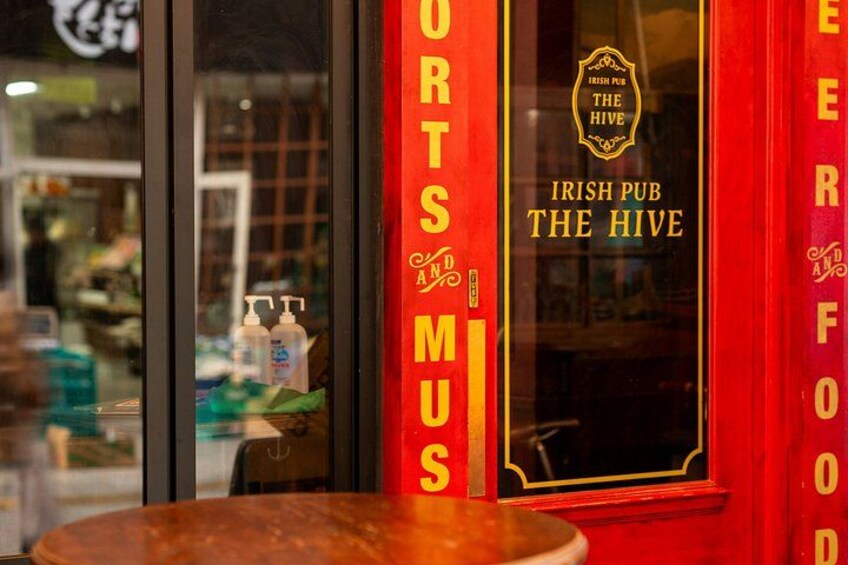 A pub named 'Irish Pub The Hive' with a red and gold sign. 5