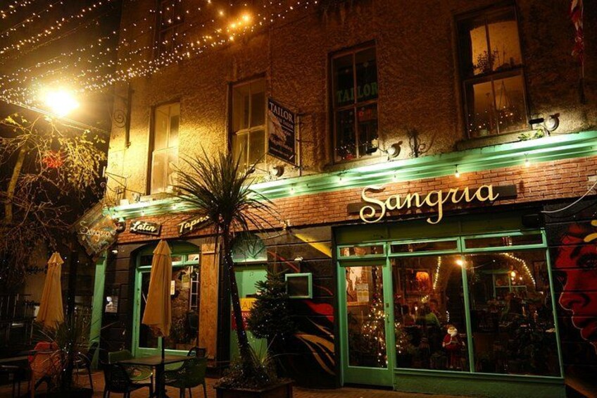 A building named Sangria with outdoor seating and string lights. 4