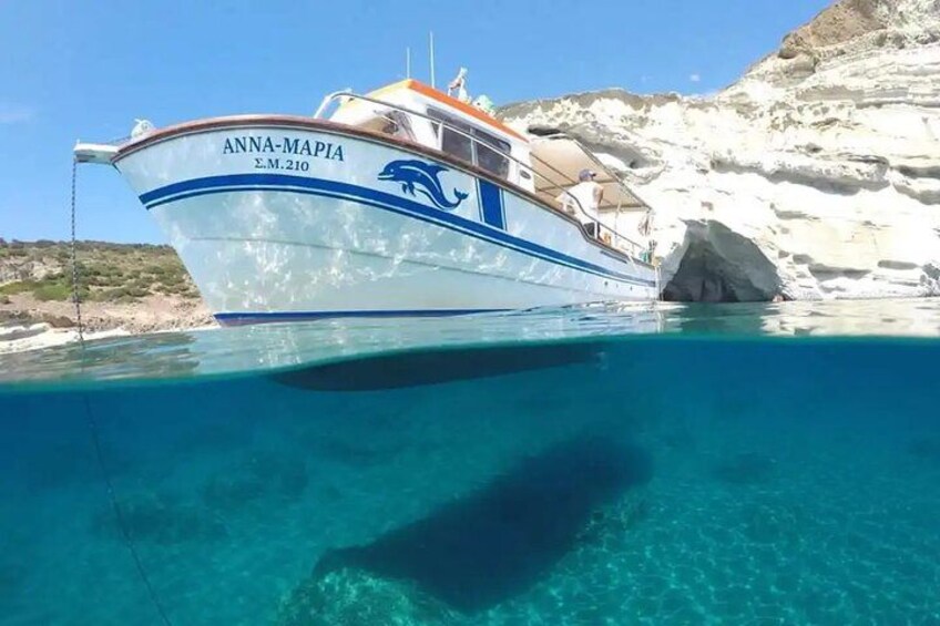 A boat named 'ANNA-MAPIA' anchored near a rocky coastline. 5