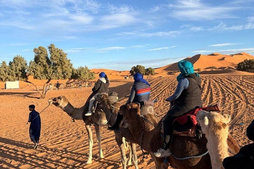 A desert landscape with camels and riders. 2