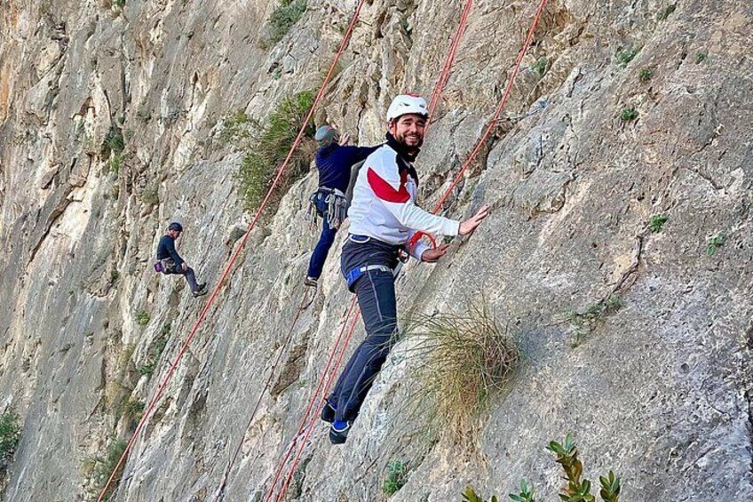 A person rappelling down a steep rock face. 1