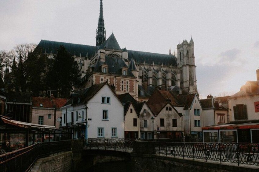 A historic building with a spire, a bridge, and a canal. 3