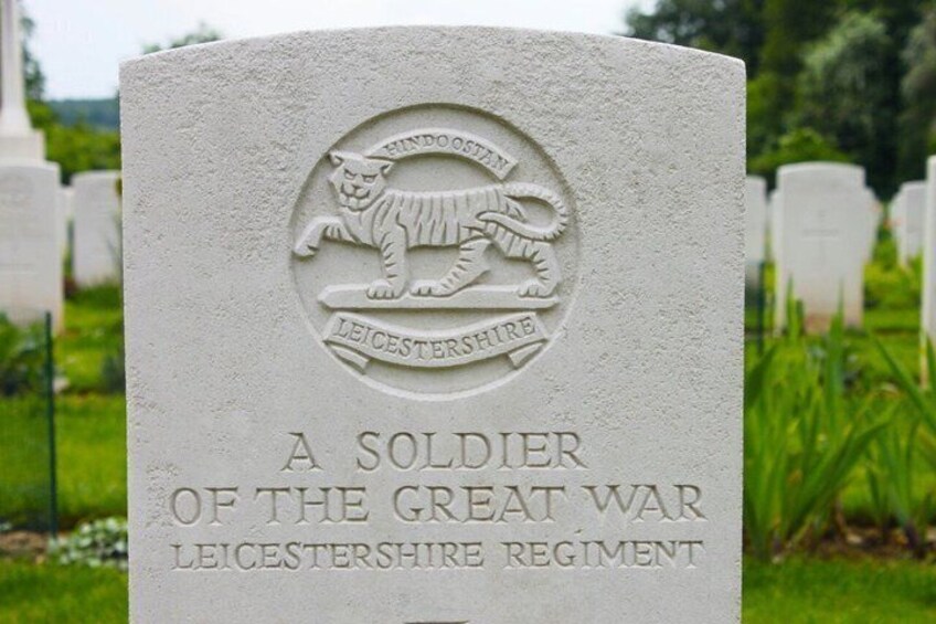 A gravestone with a leicestershire regiment emblem and a soldier's name. 2