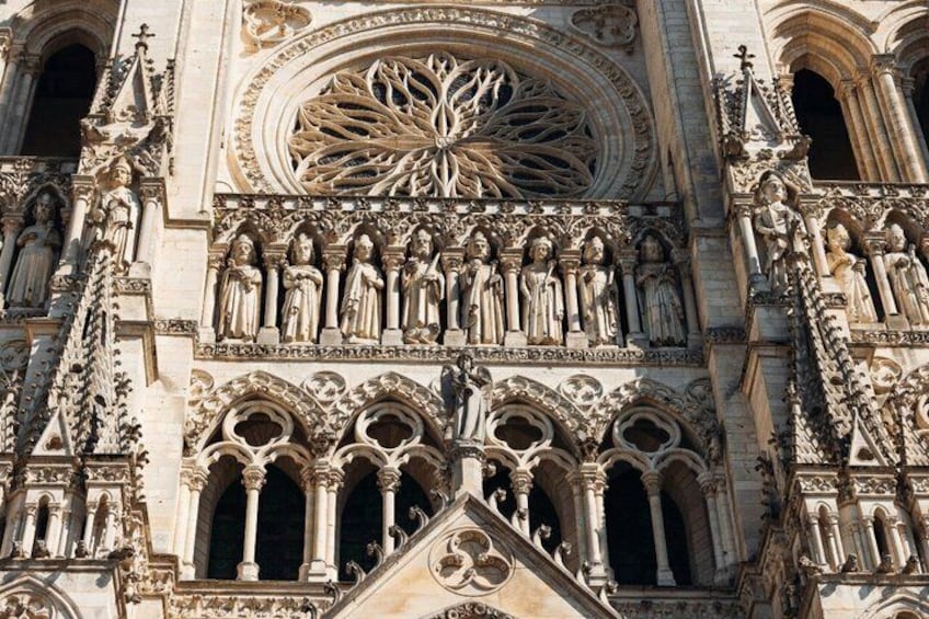 A Gothic cathedral facade with intricate stone carvings, a large rose window, and statues. 4