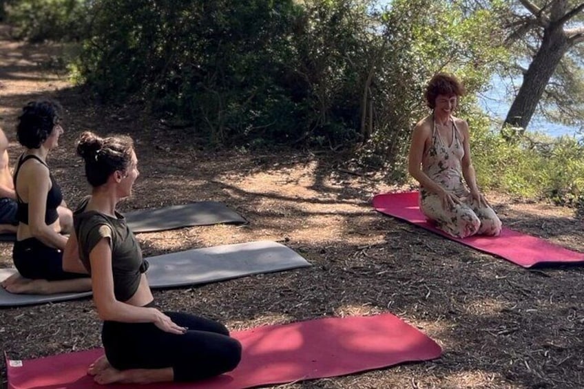 Three people sitting on yoga mats outdoors. 1