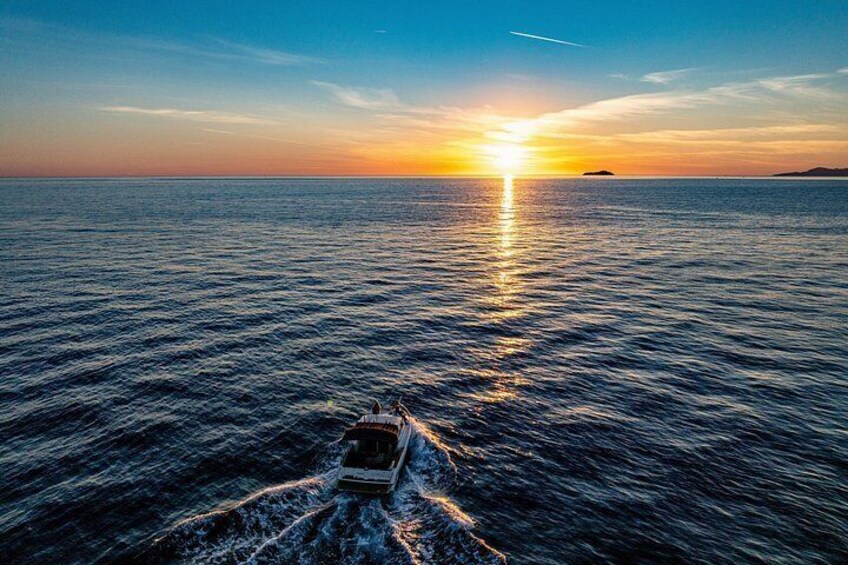 A boat on the ocean at sunset with a clear sky. 3