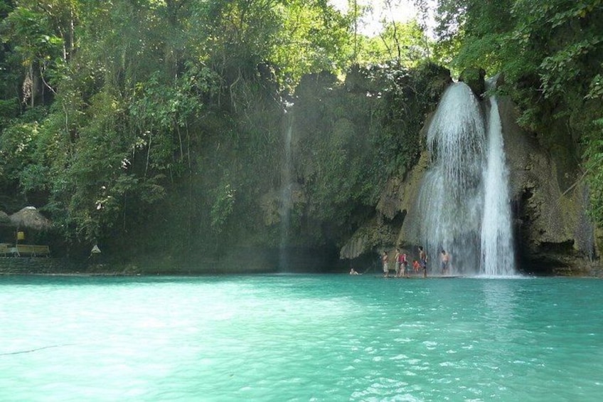 A waterfall, clear turquoise water, and lush greenery. 2
