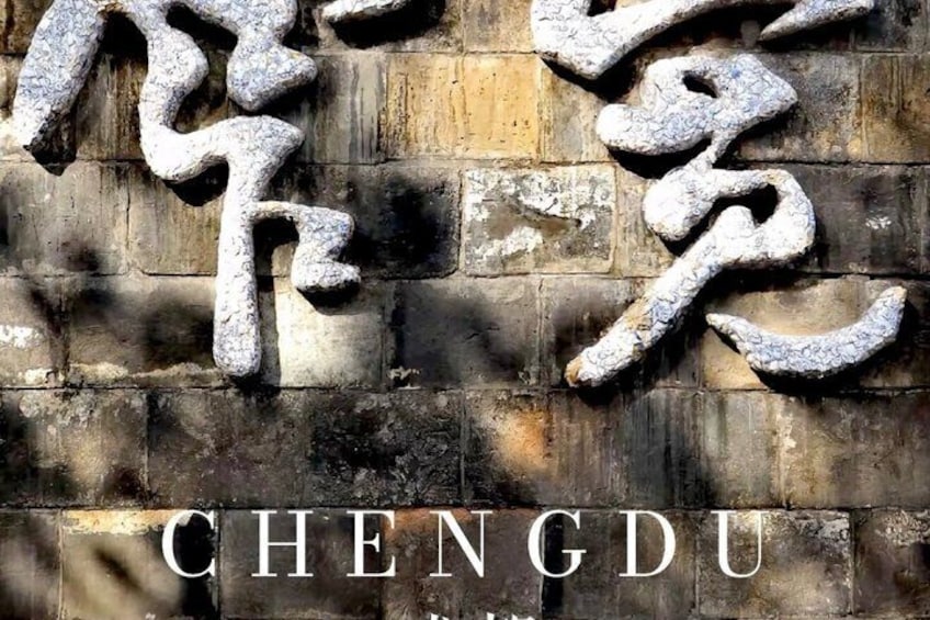 A weathered stone wall with carved Chinese characters and the word 'CHENGDU' in English. 1