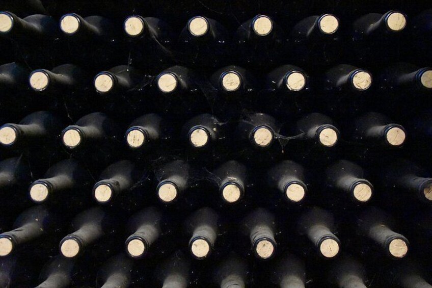 A collection of wine bottles arranged in rows. 2