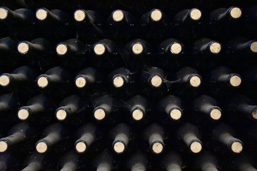 A collection of wine bottles arranged in rows. 2
