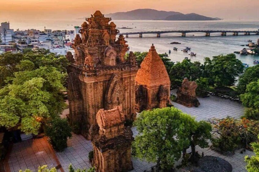 A historic temple complex with a prominent tower and a bridge in the background. 5