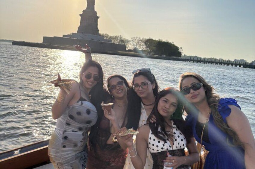 A group of people on a boat with a statue in the background. 4