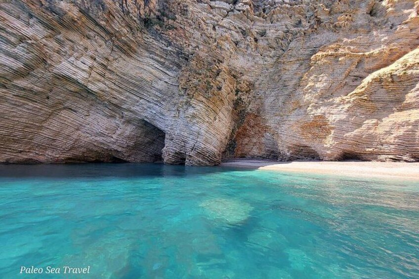 A coastal cave with clear turquoise water and rocky cliffs. 1