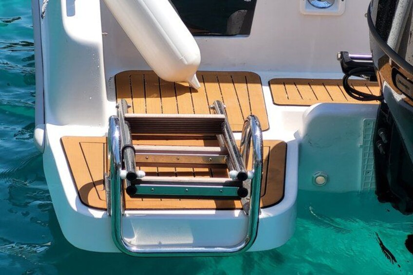 A boat's deck with a wooden bench, metal railings, and a white structure. 2