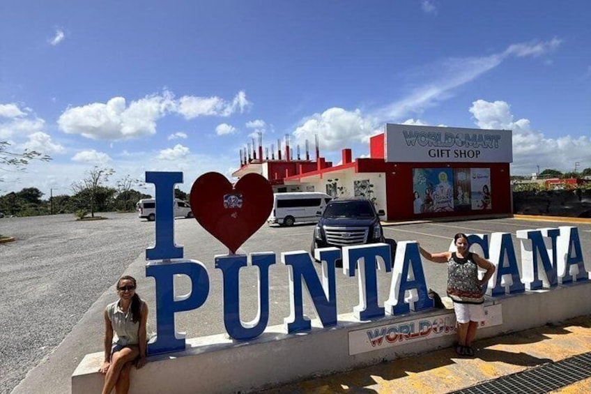 A sign with 'I ♥ PUNTA' and a gift shop in the background. 3