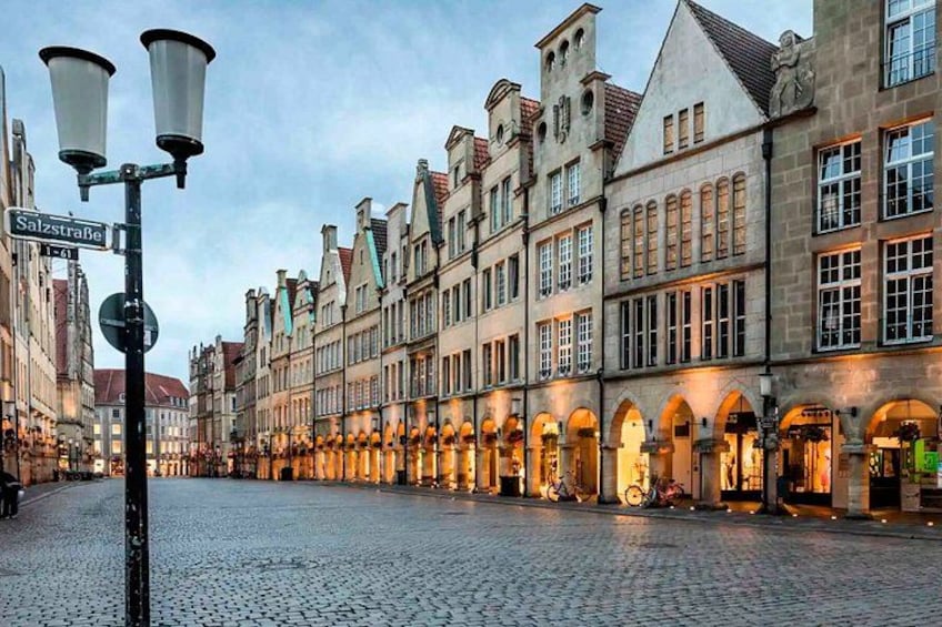 A cobblestone street lined with historic buildings, a street lamp, and a sign reading 'SalzstraBe.' 4