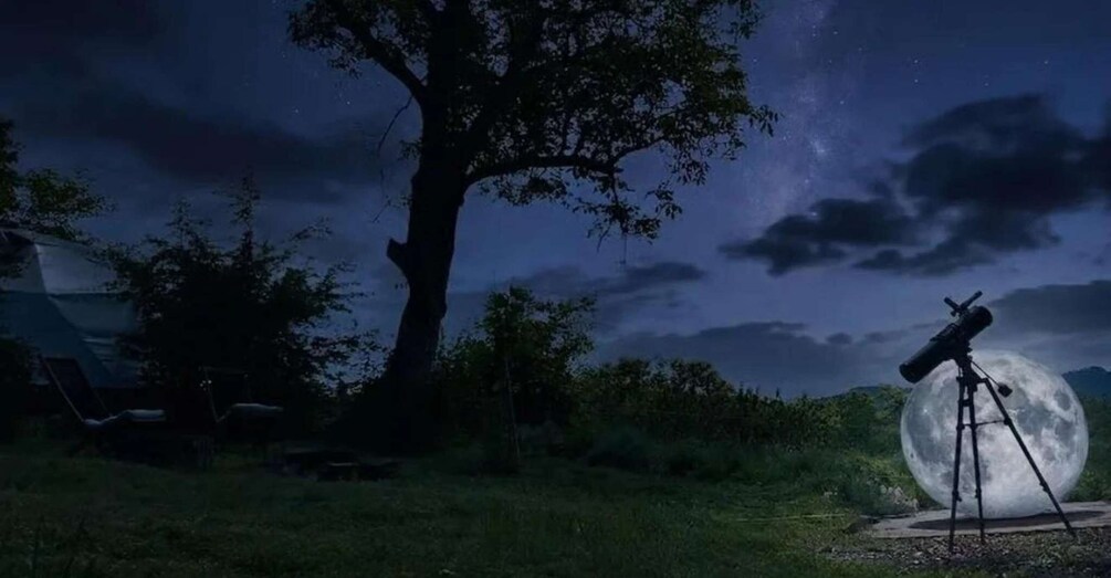A telescope aimed at a full moon, a tree, and a tent in a nighttime outdoor setting. 3