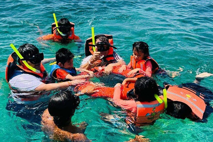 People in the water wearing life jackets and snorkels. 3
