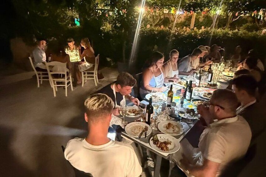 A group of people dining outdoors at night. 3
