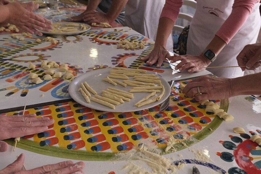 People preparing food, with a focus on pasta and dough. 1