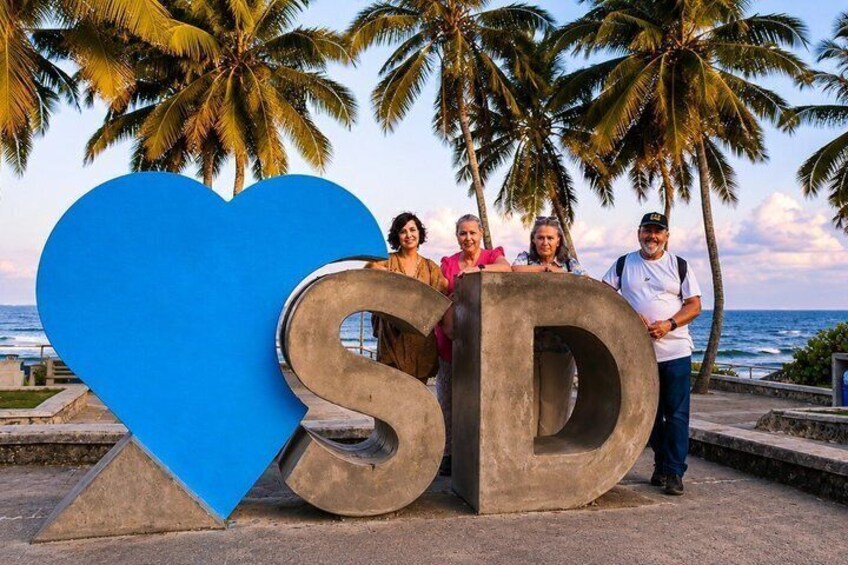 A heart-shaped sculpture with the letters 'SD' and palm trees in the background. 3