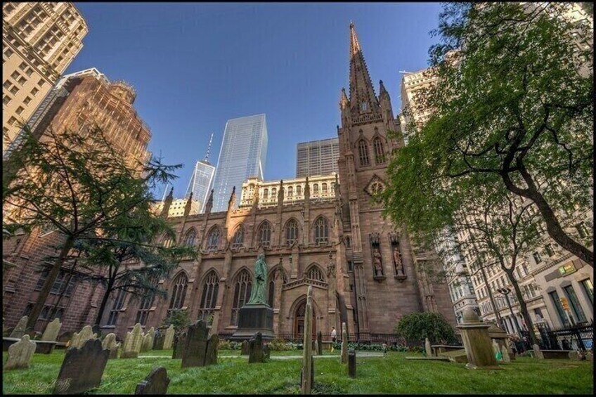 A historic church with Gothic architecture, surrounded by modern skyscrapers and a cemetery. 5