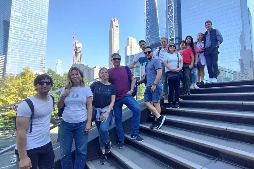 A group of people standing on a set of stairs with a city skyline in the background. 3