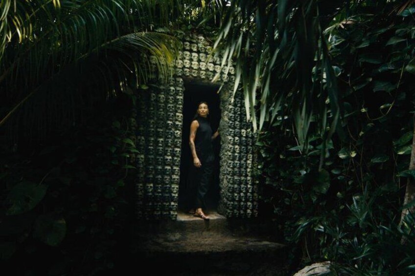 A person standing in a doorway surrounded by dense foliage. 3