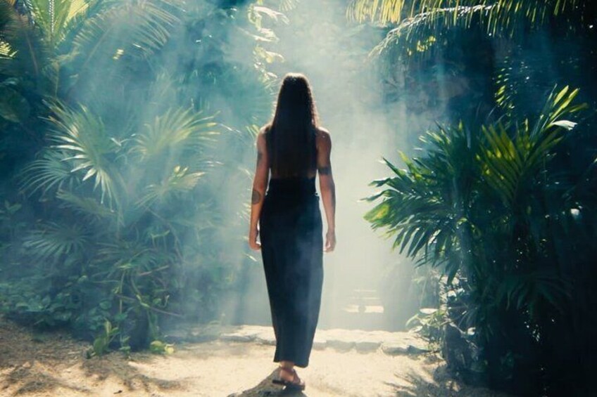 A person walking through a forested area with sunlight filtering through the trees. 5
