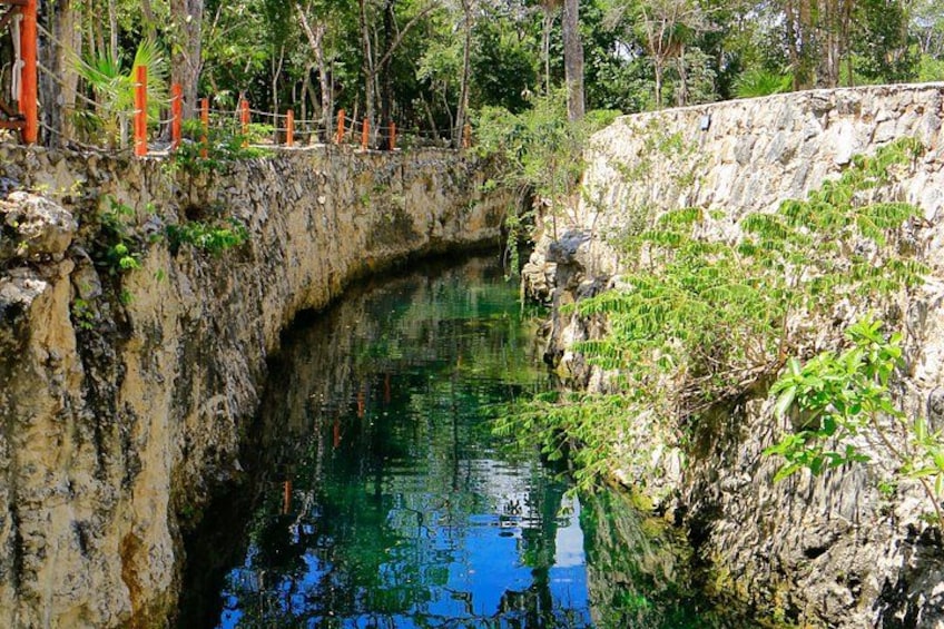 A natural water body surrounded by rocky terrain and vegetation. 1