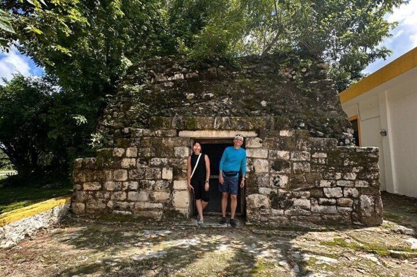 Two people standing in front of a stone structure with a doorway. 3