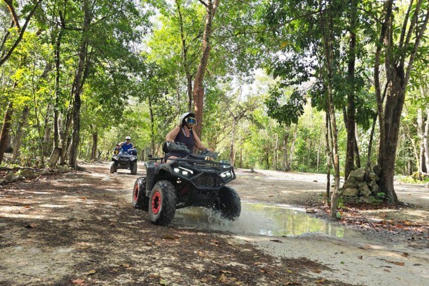Two off-road vehicles on a dirt path in a forested area. 4