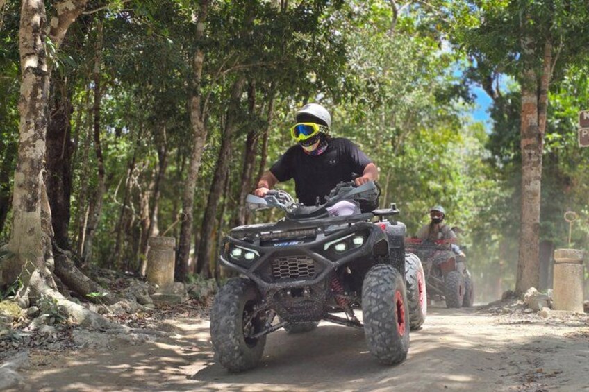 An ATV on a dirt path in a forested area. 3