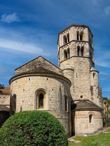 A historic stone church with a bell tower and a round tower. 4