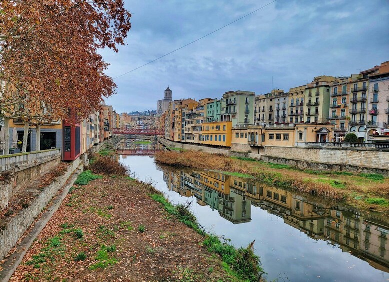 A river reflecting buildings, a bridge, and a tower in the distance. 2