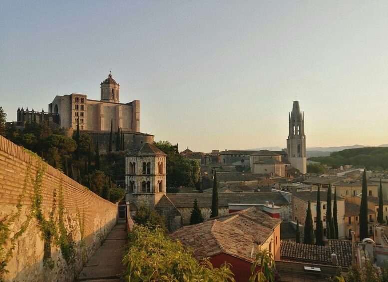 A historic town with a prominent church, a bell tower, and a fortified wall. 5